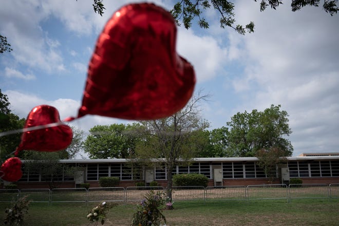 A heart-shaped balloon flies at a memorial site outside Robb Elementary School in Uvalde, Monday, May 30.
