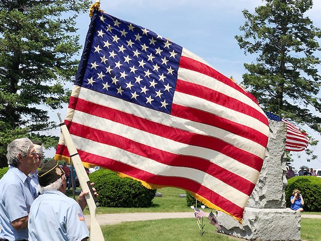 A flag is carried through Chenoa Cemetery at the start of Monday's Memorial Day service.