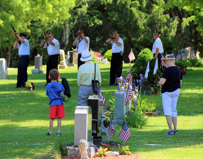 People watch the Sterling American Legion and its Color Guard firing detail at the Sterling Memorial Day ceremonies.