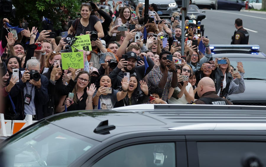 People cheer as actor Johnny Depp arrives for trial at a Fairfax County Courthouse on May 27, 2022 in Fairfax, Virginia.