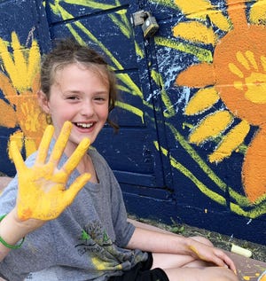 Eight-year-old Nola Reilly-Best left her mark on a mural painted by Confluence Cyclery during a painting-focused eco-art camp.