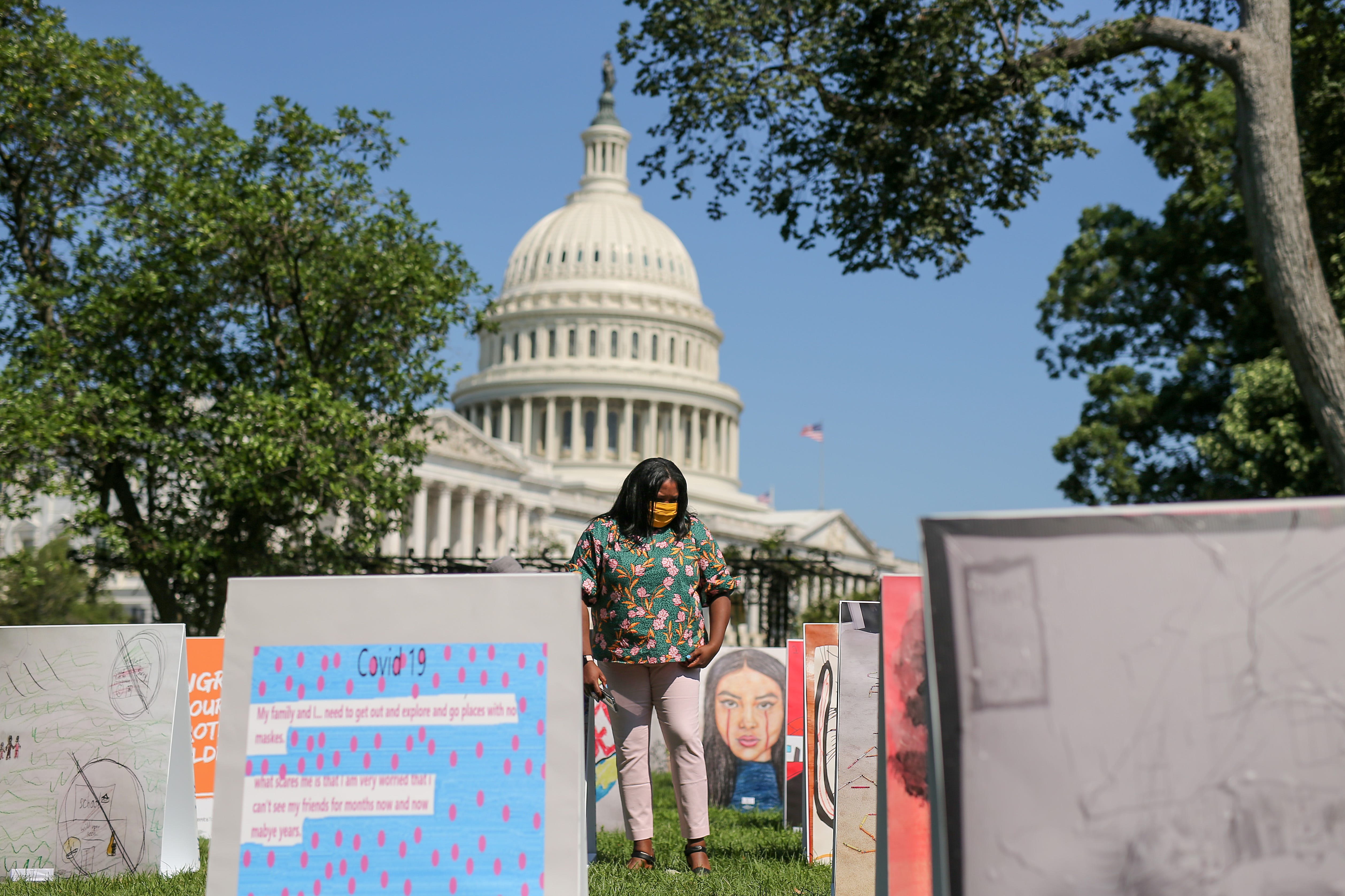Dominique Spencer looks at an art installation produced by ParentsTogether on Capitol Hill on Aug. 5, 2020. The artwork came from children across the country who described their suffering, anxiety and hopes during the coronavirus pandemic.