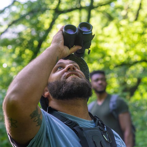 Jason Hall uses a pair of binoculars to view a bir