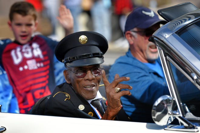 Sollie Mitchell, 103, who served in World War II as a U.S. Army staff sergeant, acknowledges the crowds while being honored as Jacksonville's oldest veteran in the November 2021 Veterans Day Parade. He died May 23.
