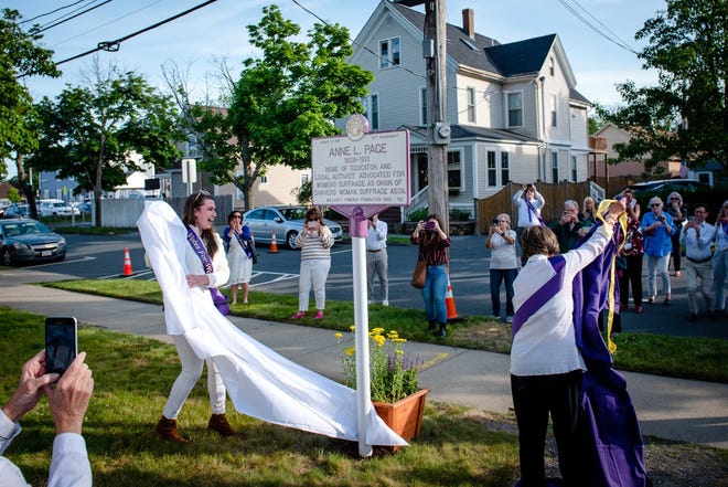 Nora Whouley (left), former assistant  communications director, Danvers Historical Society, and Sheila Cooke-Kayser, volunteer educator, Danvers Historical Society, unveil the Anne L. Page Women’s Suffrage trail marker at the Page House in Danvers May 26.