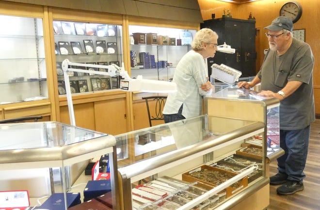 Sarah Scott, left, helps customer Michael Grau on Tuesday at the Castle Coin Shop's new location, 132 S. Sandusky Ave. Scott is the mother of owners Missie Striker and Mandy Paez.