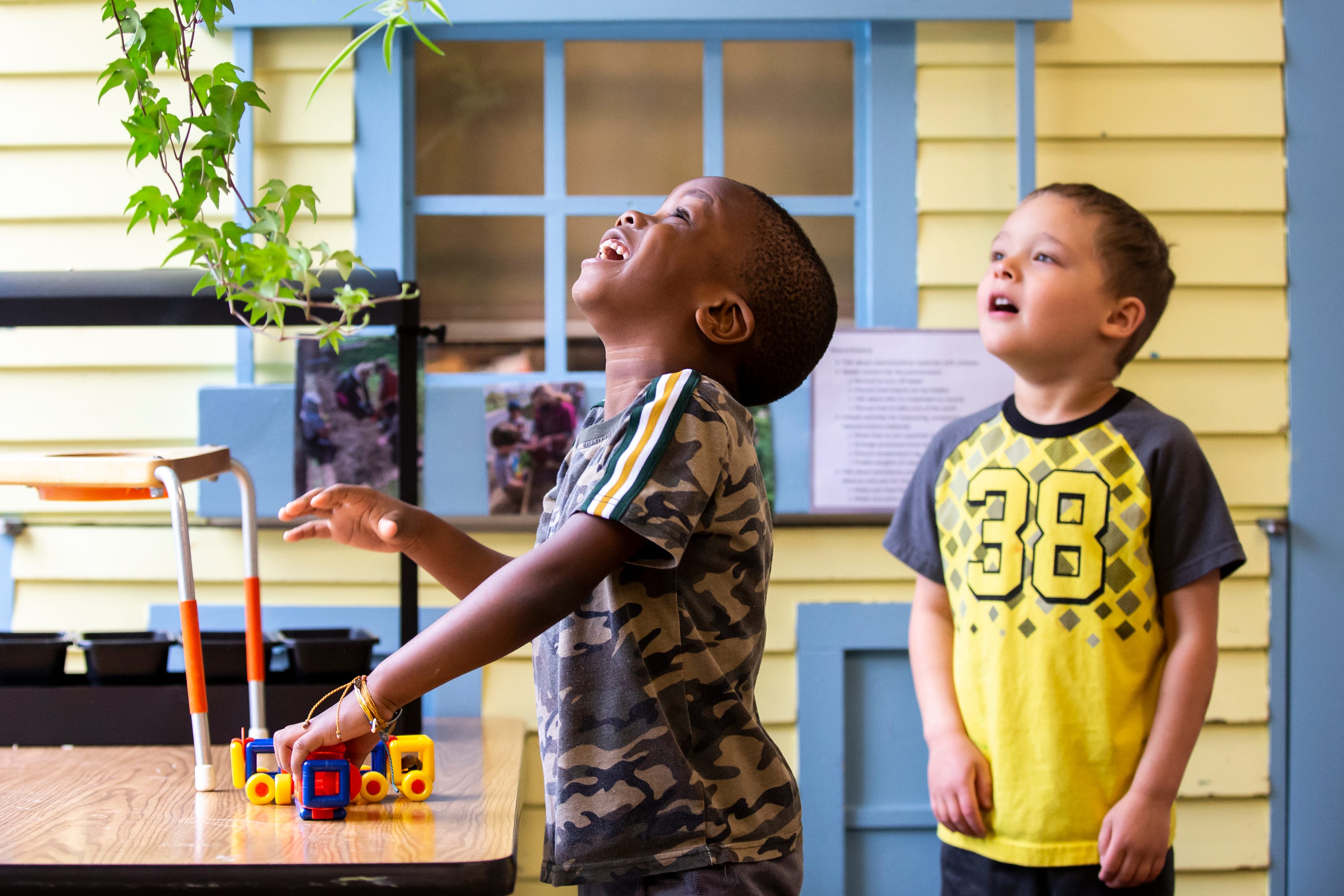 Ose Oriaifo, 3, and Calvin Hodges, 4, get a closer look at a plant hanging in the window of the DMACC Child Development Center in Ankeny on May 24, 2022.