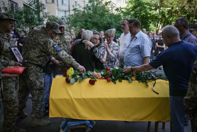 Mourners attend the June 2, 2022 funeral of Ukrainian soldier Valentin Zverik, who was killed while fighting with Russian forces in the Kharkiv region.