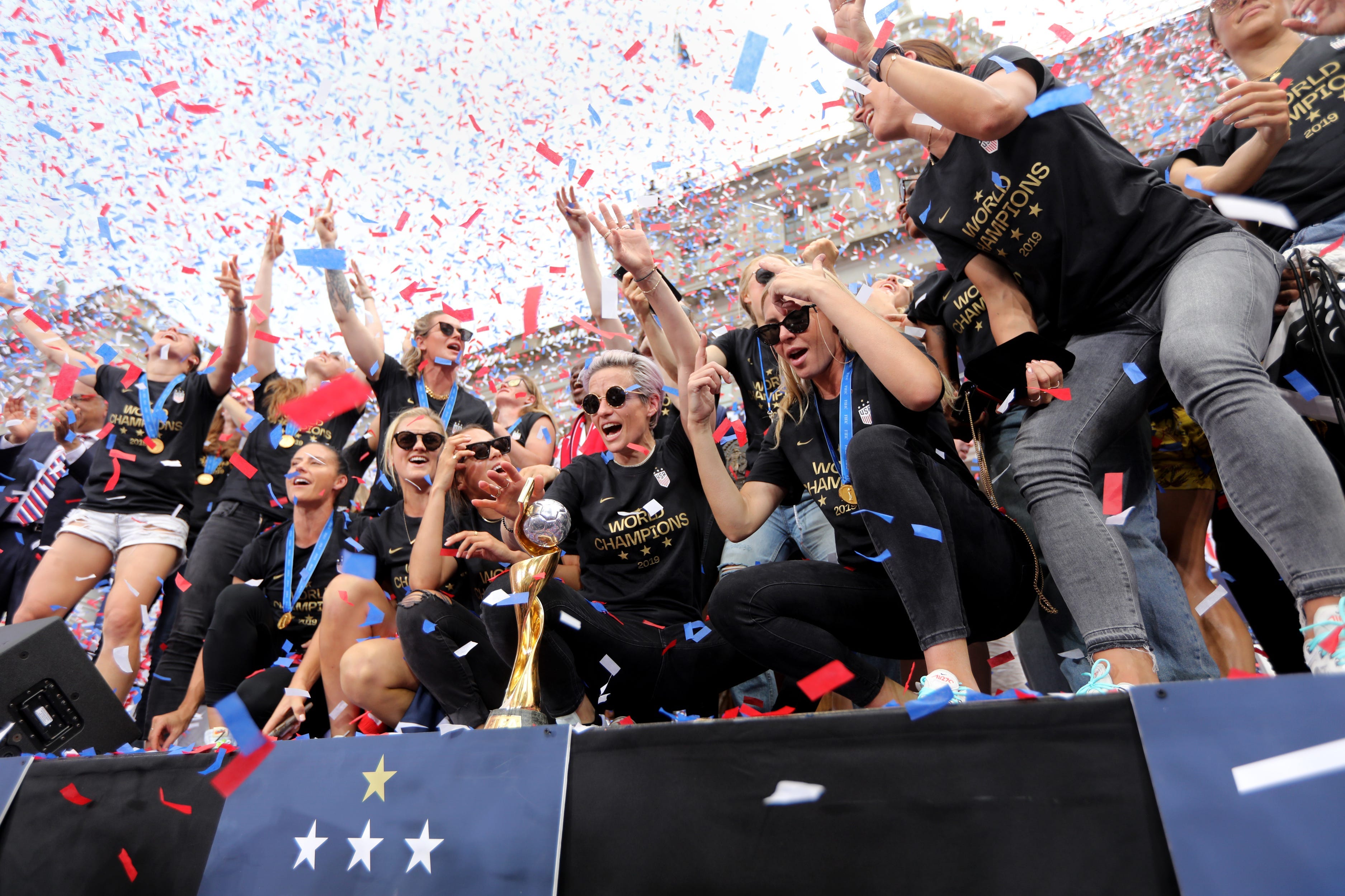 Megan Rapinoe (center, in front of trophy) and the U.S. Women's National Team, shown here after their 2019 World Cup win, finally achieved equal pay with a landmark settlement and new collective bargaining agreement in 2022.