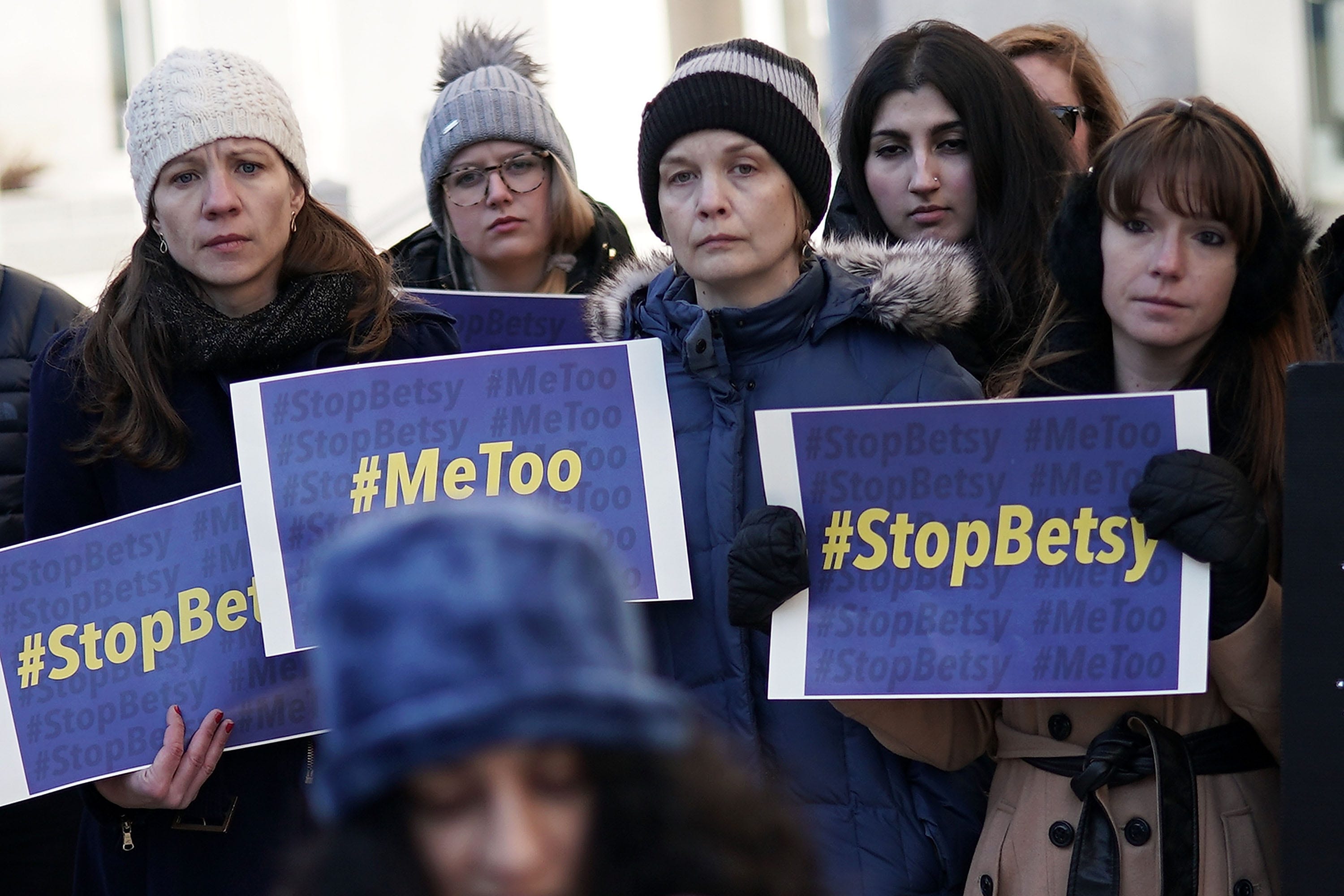 Activists hold signs during a news conference on a Title IX lawsuit outside the Department of Education January 25, 2018 in Washington, DC.