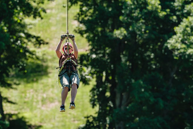 In celebration of her 86th birthday, Ellen Jones of Winfield rides a zip line Saturday at Wood's Tall Timber Resort in Goshen Township.