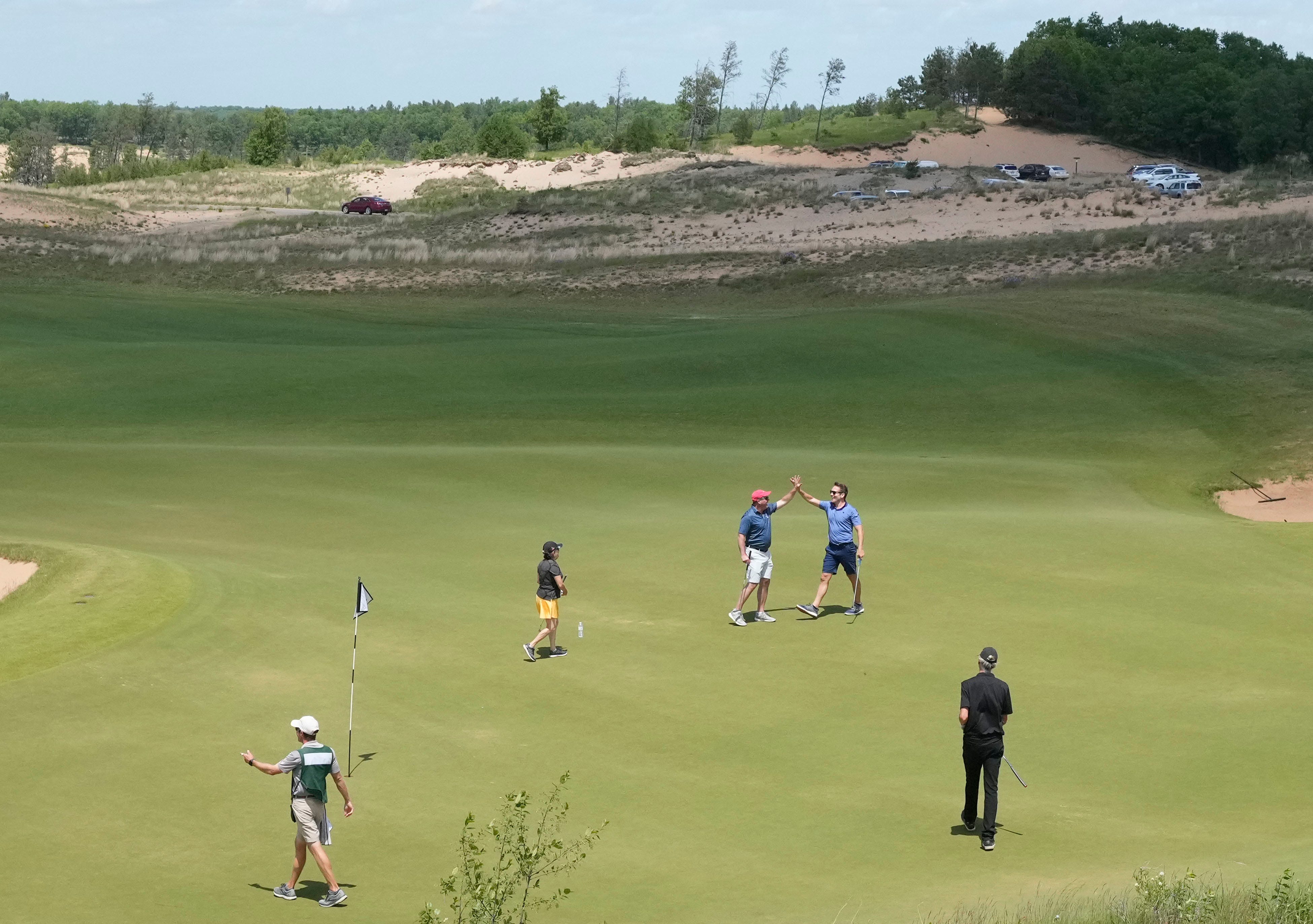 Golfers celebrate a putt on the 18th hole at the Sand Valley course at Sand Valley Golf Resort in Rome on June 2.