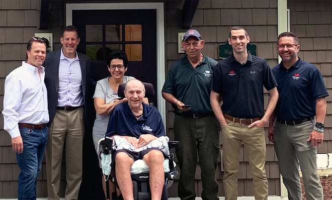 Christiana and Mike Ernst with some of the contractors who helped with the renovation of their summer camp to help make it more usable with his ALS.
