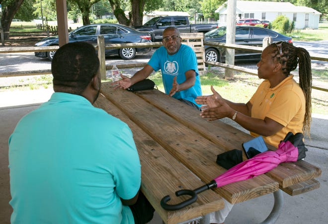 Cantonment Improvement Committee member Josh Womack, center, talks with Finna Clay, right, and TJ Lee about areas of concern in the neighborhood during a meeting at Carver Park on Monday.
