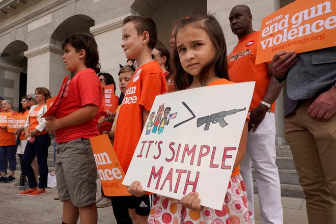 Elise Schering, 7, displays a simple message during a National Gun Violence Awareness rally at the Capitol in Sacramento, Calif., on Thursday, June 2, 2022. In acknowledgment of Gun Violence Awareness Day, Gov. Gavin Newsom announced on Friday, June 3, 2022, that California is spending $11 million on education programs promoting wider use of "red flags" orders that are designed to temporarily take guns away from people who are deemed at risk of harming themselves or others.