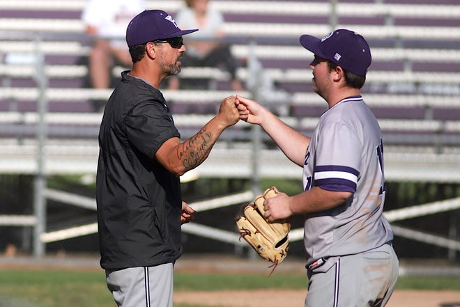 Burlington assistant coach Matt Rascon fist bumps with Hunter Ford (11) at the end of an inning against Muscatine Tuesday June 7, 2022 at Wayne Duke Field in Burlington.