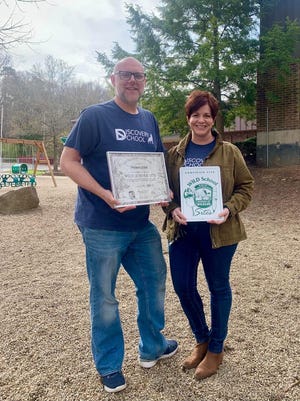 The Wildlife Discovery School Assistant Head of School Simon Clark and Head of School Julie Schwartz display the Wild School Sites certificate.