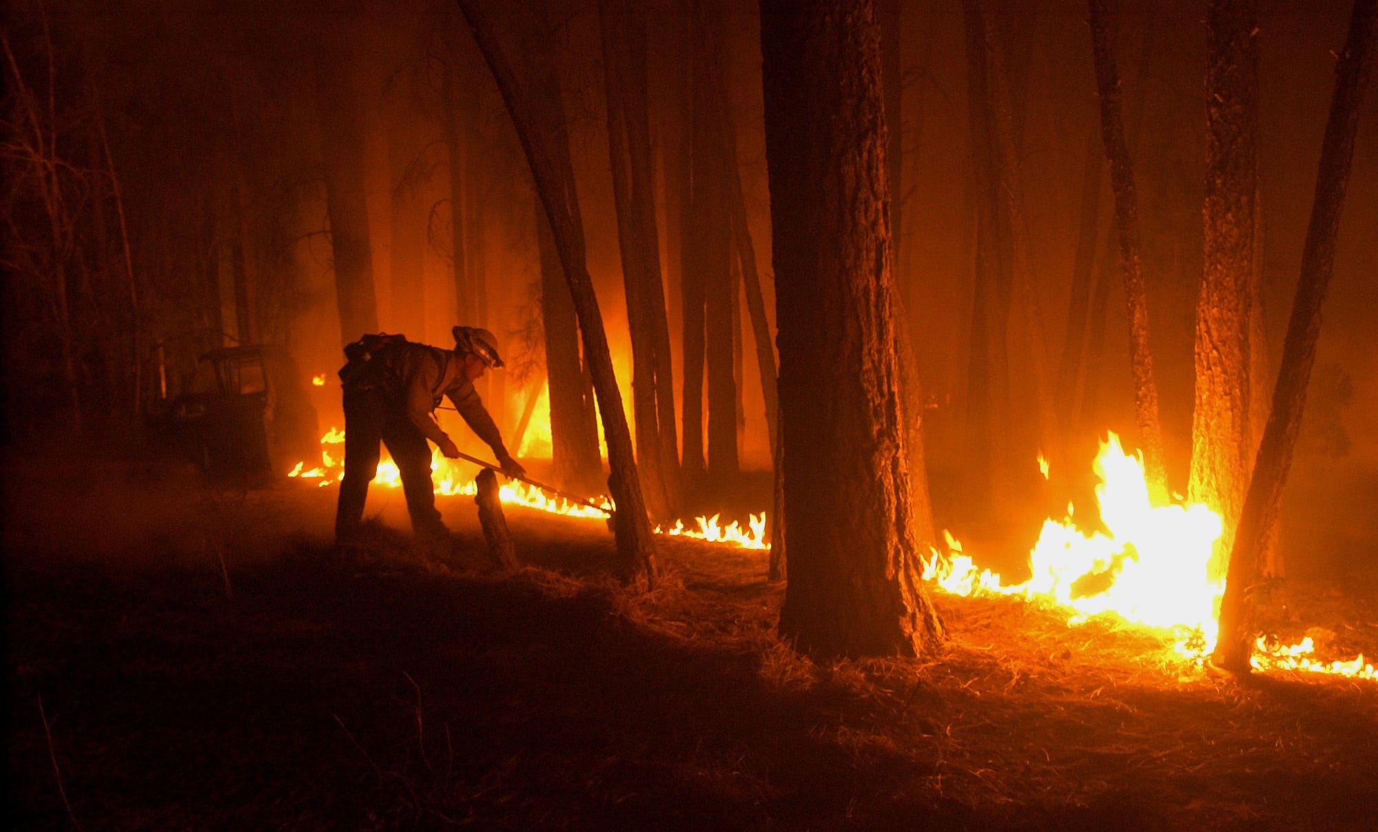 Dan Loli of Tri City Fire District creates a fire line in the backyard of a residence in Fool's Hollow on June 23, 2002.