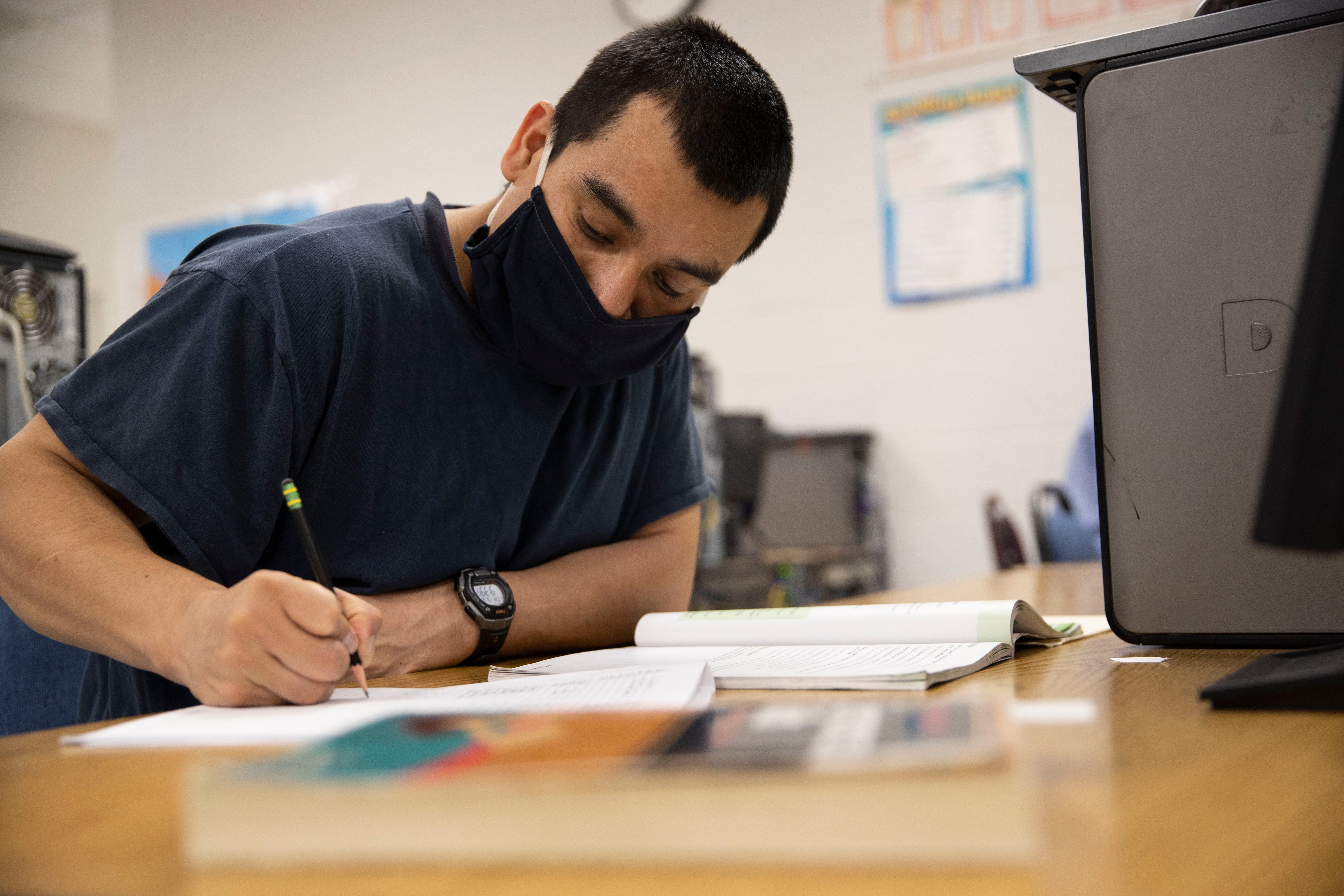 Abelino Garcia-Vasquez studies during a class at Snake River Correctional Institution in Ontario in May.