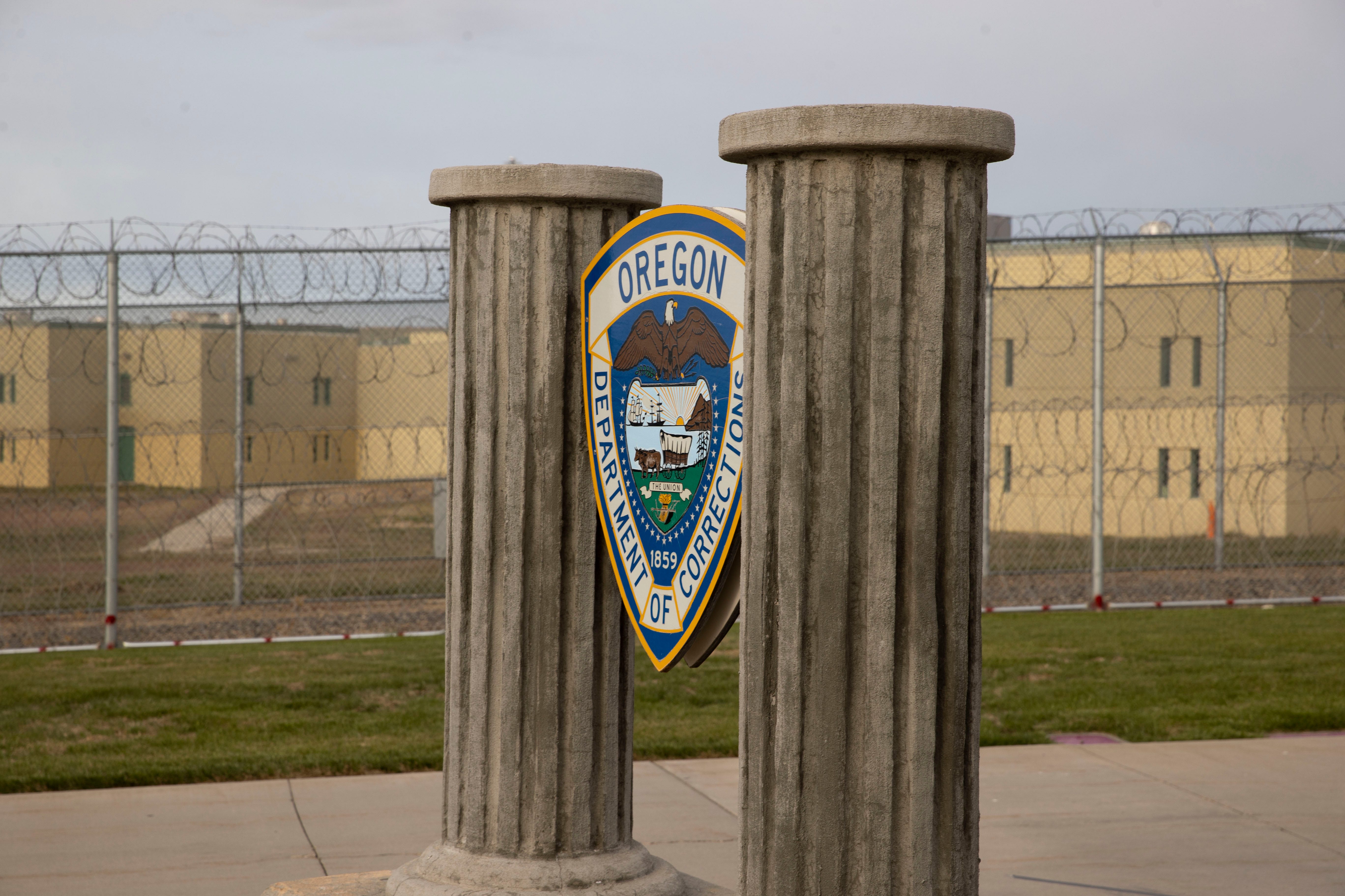 Columns and the Oregon Department of Corrections sign greet visitors at Snake River Correctional Institution in Ontario, Ore., on Thursday, May 12, 2022.