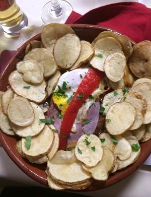 Bife Portuguesa no Taunton Sports Club Restaurant é coberto com ovo, presunto e pimenta vermelha e servido com batatas fritas.