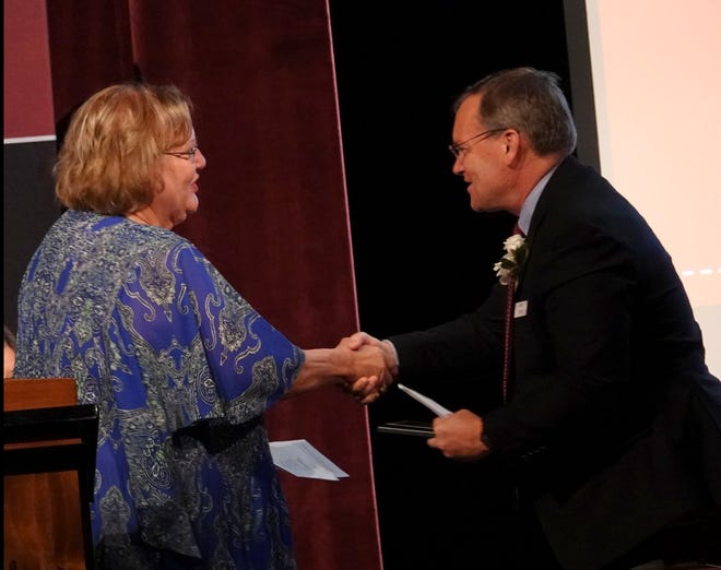 Charlevoix Public Schools Superintendent Mike Ritter (right) congratulates Jan Boss (Class of 1975) during the Charlevoix High School Alumni Hall of Fame induction ceremony on June 3 in the middle/high school auditorium.