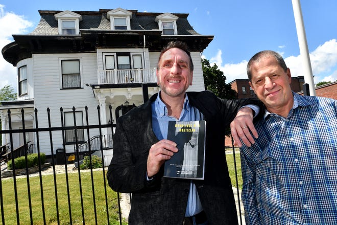 Frank Quaglia and Art Sensovich hold "Mumblings of a Mortician" in front Graham Putnam & Mahoney Funeral Parlors in Worcester. The two worked with longtime city mortician Peter A. Stefan on the book, which was published just before Stefan's death in March.