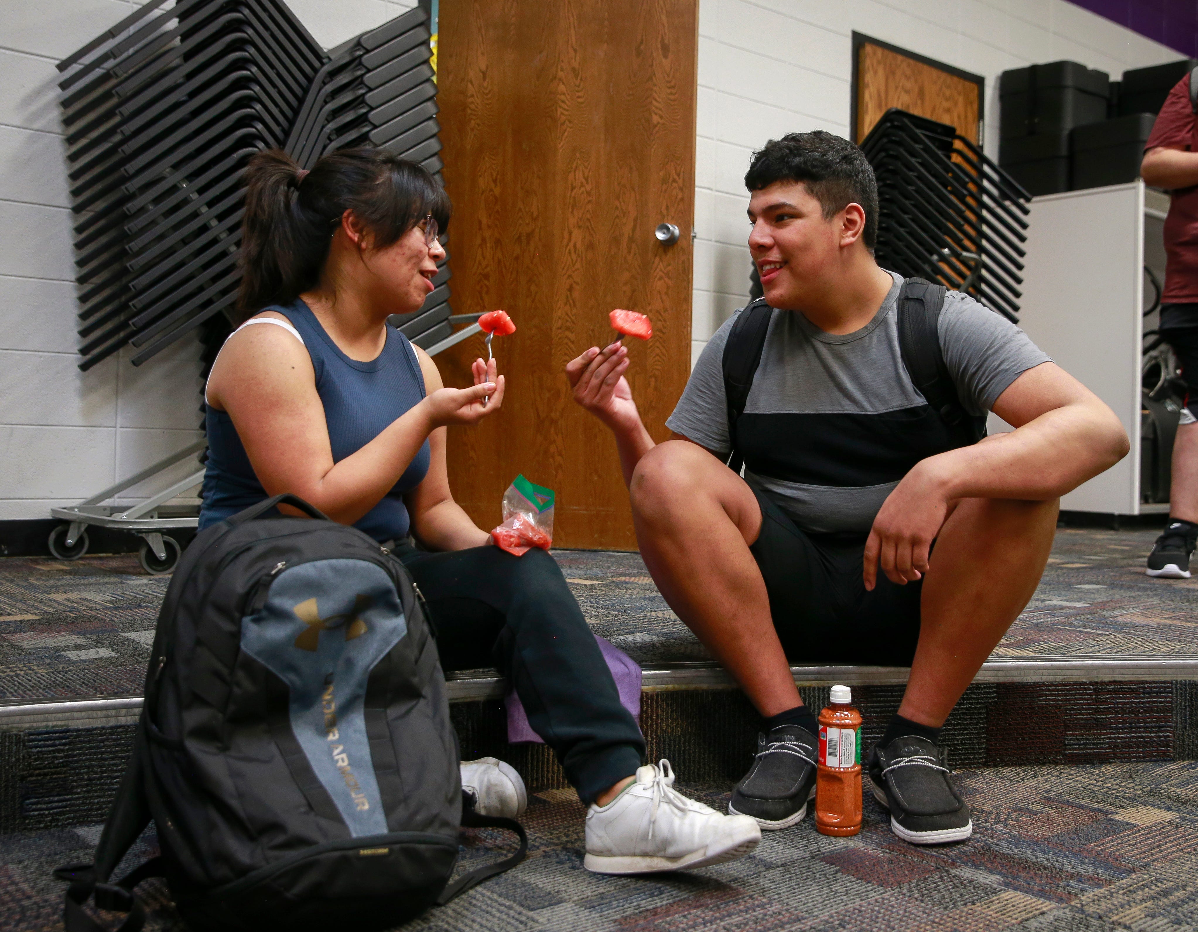 Junior Sofia Guzman shares watermelon with junior Adrian Velazquez-Nieto after band practice at Denison High School.