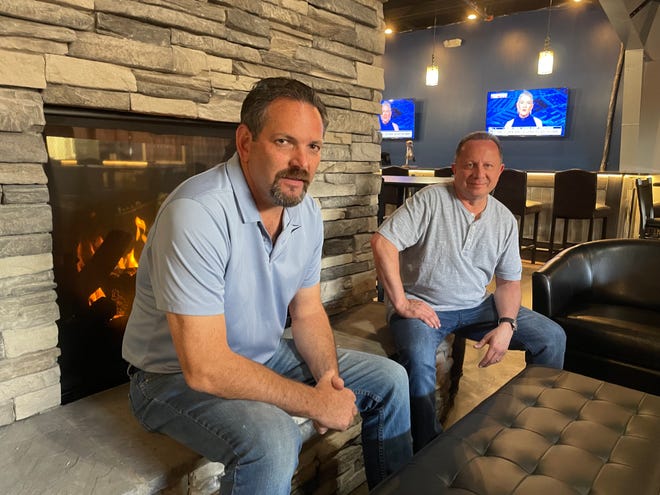 The Canopy Lounge co-owners Bill Opre, left, and John Kallabat sit Thursday, June 9, 2022, next to a two-sided fireplace at The Canopy Lounge, a new Brighton bar and restaurant opening soon.