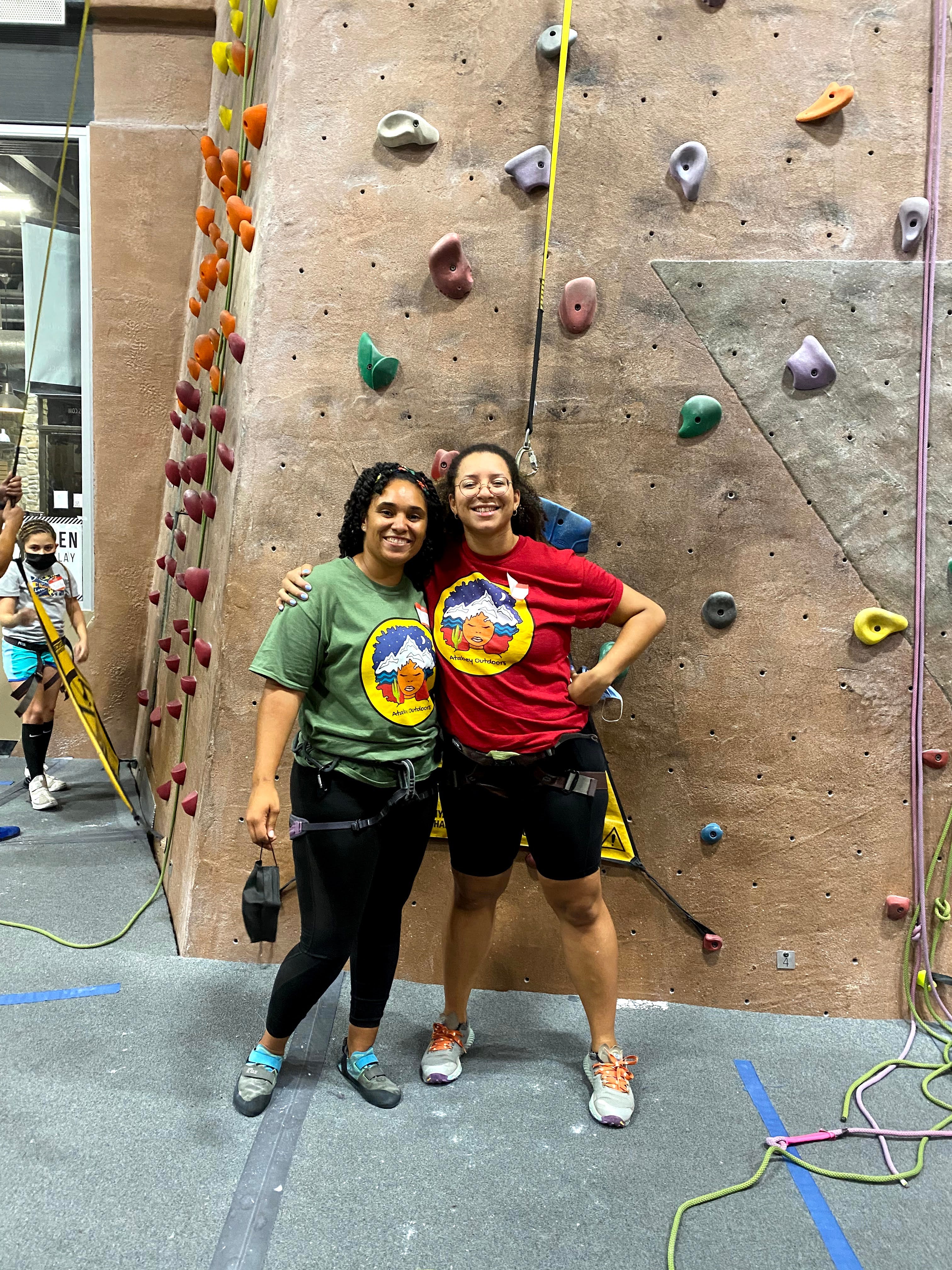 Atabey Outdoors Founder Raquel Gomez and volunteer Quin Works pose for a photo after indoor rock climbing.