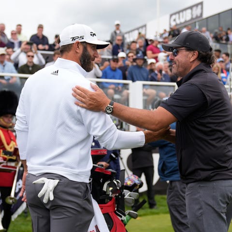Dustin Johnson, left, and Phil Mickelson greet eac