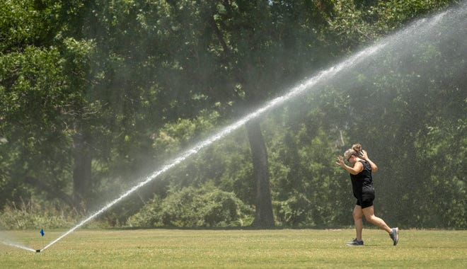 Samantha Smoot cools off in a sprinkler at Austin's Zilker Park on a sizzling afternoon last Friday. “I like to exercise in heat but you can’t bypass a sprinkler,” Smoot said. Austin temperatures soared to 103 degrees that day, the fifth in a row that temperatures hit triple digits. But on Wednesday, Austin's string of days with 100-degree heat ended with a high of only 98. The nine straight days of triple-digit temperatures we had this month is the longest such hot streak since August 2020, when Austin had 20 consecutive days of 100-degree temperatures.