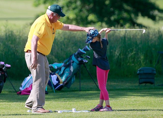 Instructor Dan Priest gives Esther Williams instruction and pointers on her stance and how to address the ball on the instructional course on the range at the Brookside Junior Golf program Friday, June 10, 2022. The Junior Golf program is celebrating it's 50th anniversary. TOM E. PUSKAR/ASHLAND TIMES-GAZETTE