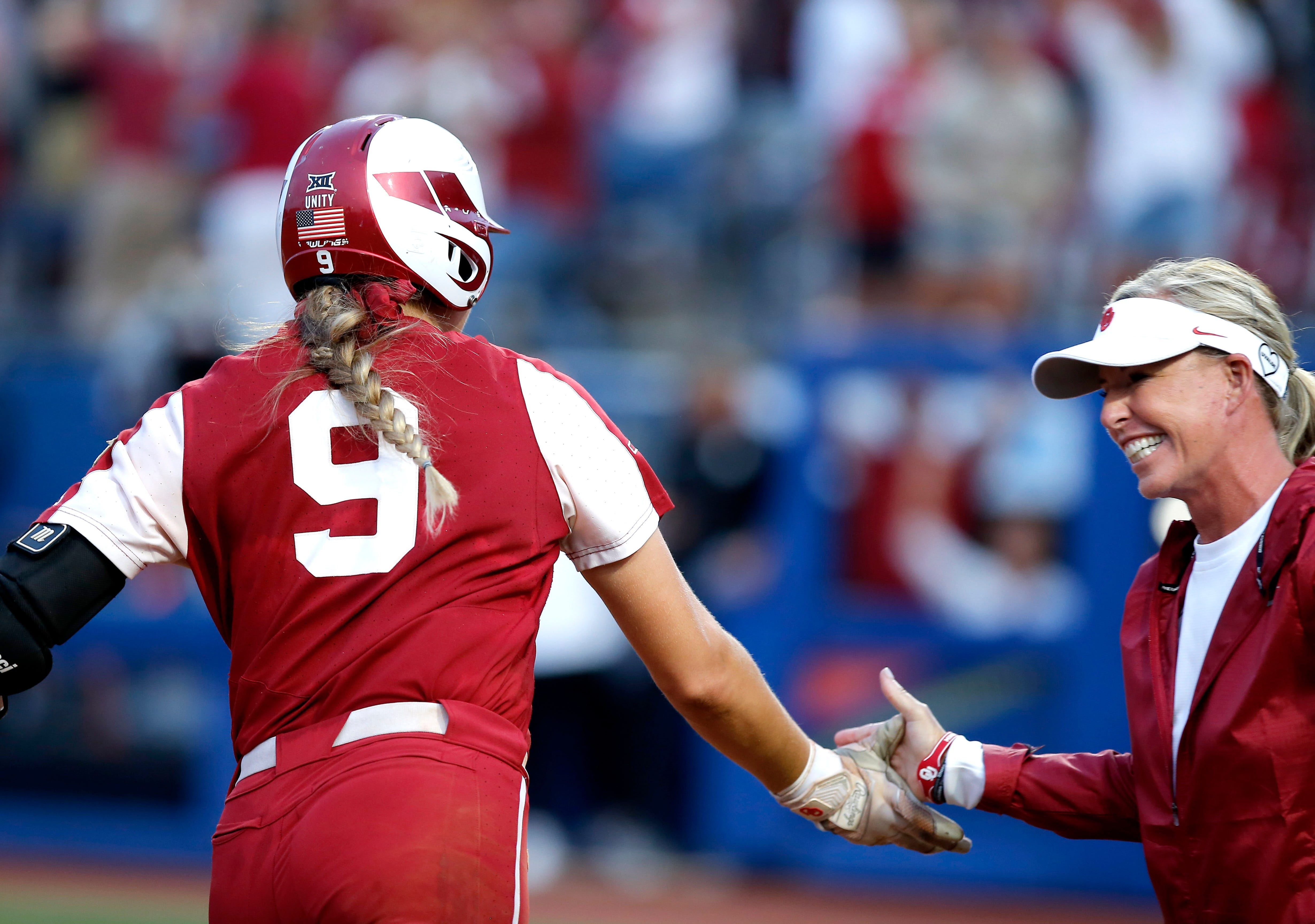 OU catcher Kinzie Hansen (9) celebrates a home run with head coach Patty Gasso in the fifth inning of Game 2 of the WCWS finals against Texas on June 9.