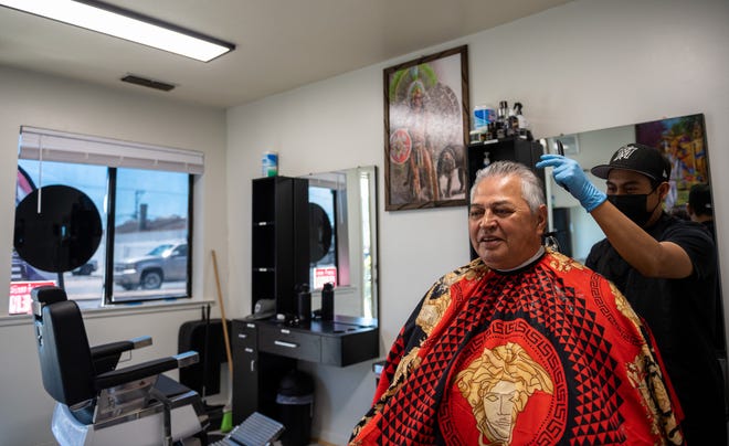 Gabriel Toledano, de 30 años, propietario de Mixteco Barber Shop, corta el cabello de un cliente dentro de su tienda en Salinas, California, el jueves 9 de junio de 2022.
