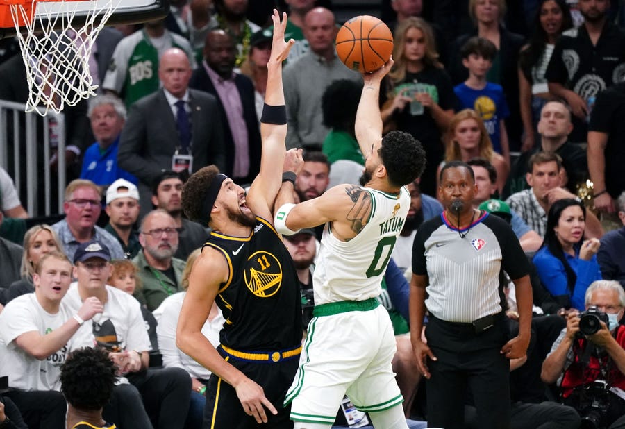 Game 4: Celtics forward Jayson Tatum (0) tries to shoot over Warriors defender Klay Thompson (11) during the second half.