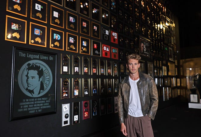 Austin Butler, the actor portraying Elvis Presley in Baz Luhrmann's new biopic, poses for a portrait with Elvis' gold records at Graceland, Presley's home in Memphis.