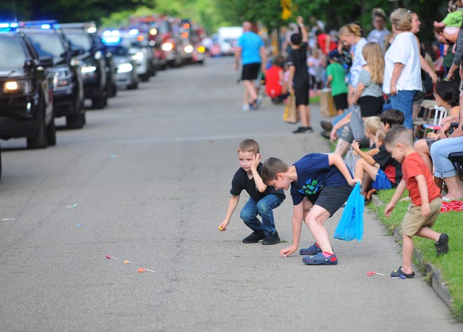 A young boy covers his ear as sirens blare from emergency vehicles taking part in the Sebring Firemen's Festival Parade roll past. He and his pals jumped out into the street Friday, June 10, 2022, to grab candy thrown from the vehicles and participants in the parade.