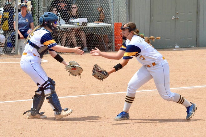 South Lyon's Madison McKenzie (left) and Ava Bradshaw (right) celebrate a strikeout during the Division 1 softball regional final against Dexter on Saturday, June 11, 2022, at Northville.