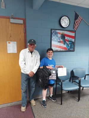 Taegan Custard (right) was recently presented with a backpack, t-shirt and certificate for having participated in the St. Jude Bike-a-thon last October by event coordinator and former Cheboygan County Probate Court Judge Robert Butts. Custard's name was drawn to be given the backpack from the event.