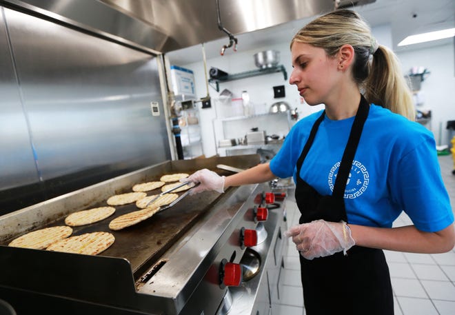 Owner and manager Olta Joxhe tends to fresh pita bread on the grill at Grilla Greek Kouzina on Broadway in Taunton on Friday, June 10, 2022. 