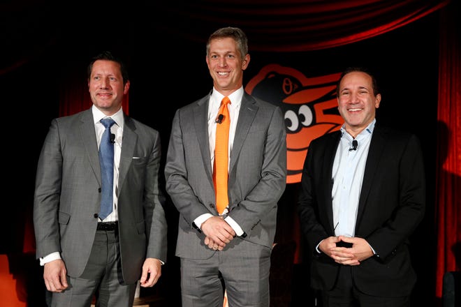 FILE - Mike Elias, center, the Baltimore Orioles' new executive vice president and general manager, poses for a photo with Orioles ownership representative Louis Angelos, left, and executive vice president John Angelos, right, after a baseball news conference Nov. 19, 2018, in Baltimore. Orioles CEO John Angelos was accused in a lawsuit this week of seizing control of the team at the expense of his brother Lou â€” and in defiance of their father Peter's wishes. (AP Photo/Patrick Semansky, File)