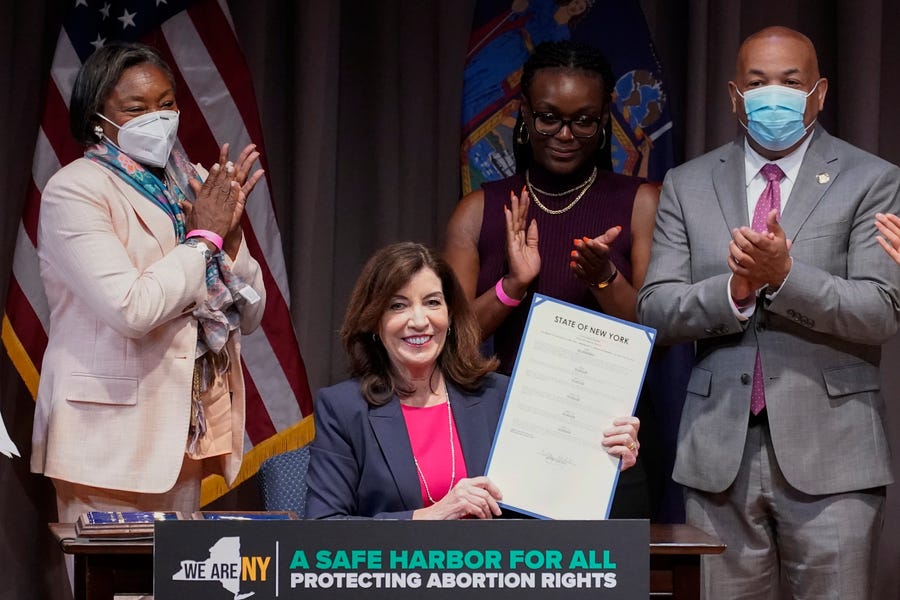 New York Gov. Kathy Hochul, center, poses for photos after signing a legislative package to protect abortion rights during a ceremony in New York, Monday, June 13, 2022. New York has expanded legal protections for people seeking and providing abortions in the state under legislation signed by Gov. Hochul on Monday. (AP Photo/Mary Altaffer) ORG XMIT: NYMA102
