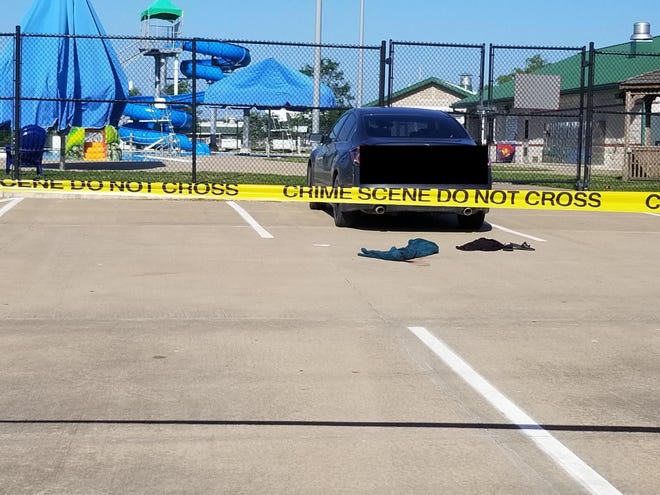 An abandoned towel and flip flops remain on the ground of the parking lot of the West Burlington Swimming Pool Tuesday, where a shooting occurred at 5 p.m. The pool was subsequently evacuated.