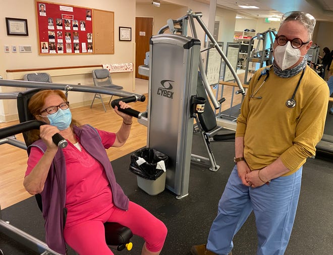 Libby Bottero, left, a participant in RiverBend's supervised exercise program, lifts weights with respiratory therapist Robert Stalbow.