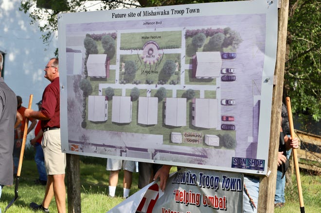 A board showing a drawing of the Mishawaka Troop Town sits on property where the tiny-duplex village will for transitional housing for veterans will be built. The groundbreaking was held Tuesday night on land next to VFW Post 360 on East Jefferson Boulevard in Mishawaka.