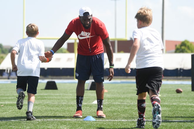 Former Titans player Gerald McRath coaches kids at a Tennessee Titans youth football camp held at Hardin Valley Academy, Wednesday, June 15, 2022.