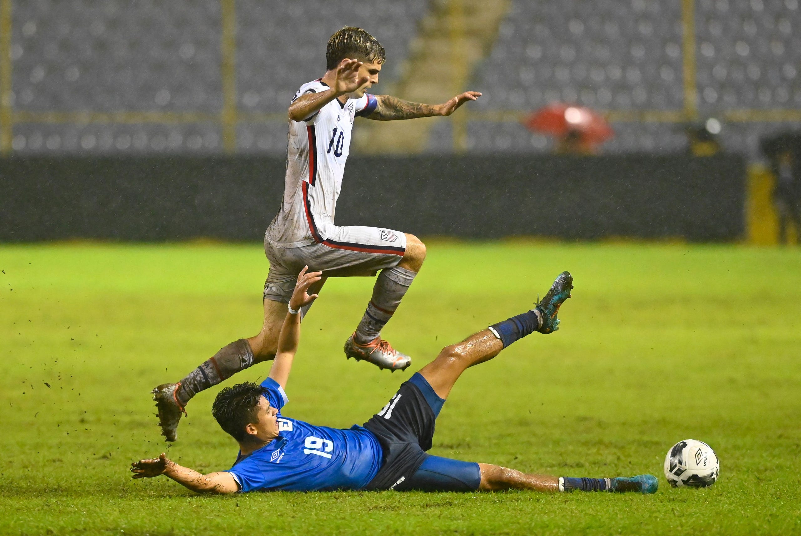 Kevin Reyes of El Salvador (L) vies for the ball with Christian Pulisic of USA during a Concacaf Nations League football match at the Cuscatlan Stadium, in San Salvador, on June 14, 2022.