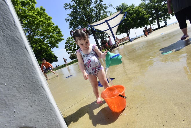 Calliegh VanBranda, 2, fills up her bucket with water during a hot morning at the splashpad in Lakeside Park in Port Huron on Wednesday, June 15, 2022. Her grandmother Denise Medrano, a Capac resident, brought Calleigh to enjoy the splashpad.