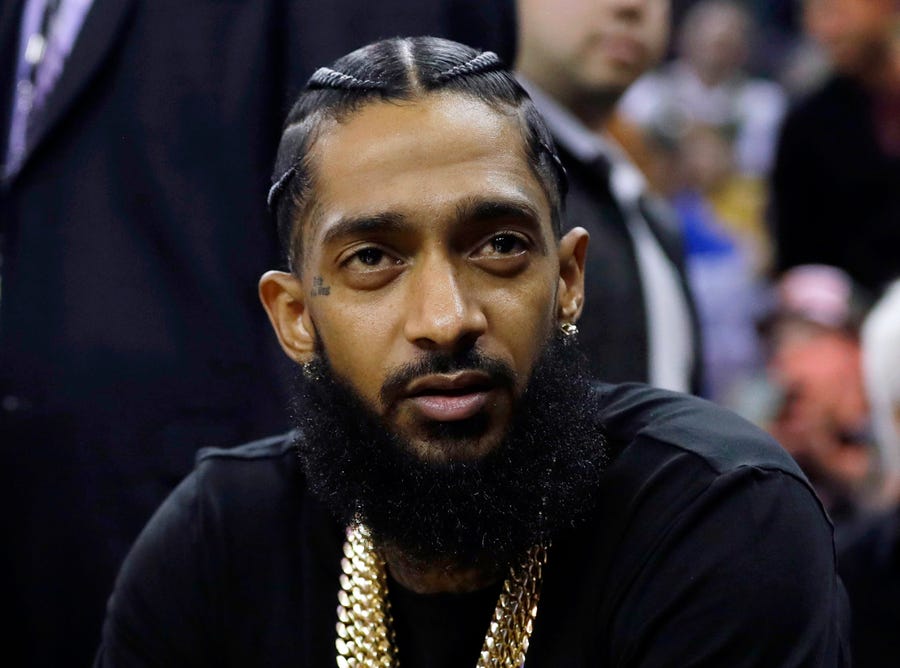 Rapper Nipsey Hussle attends an NBA basketball game between the Golden State Warriors and the Milwaukee Bucks in Oakland, Calif., on March 29, 2018.